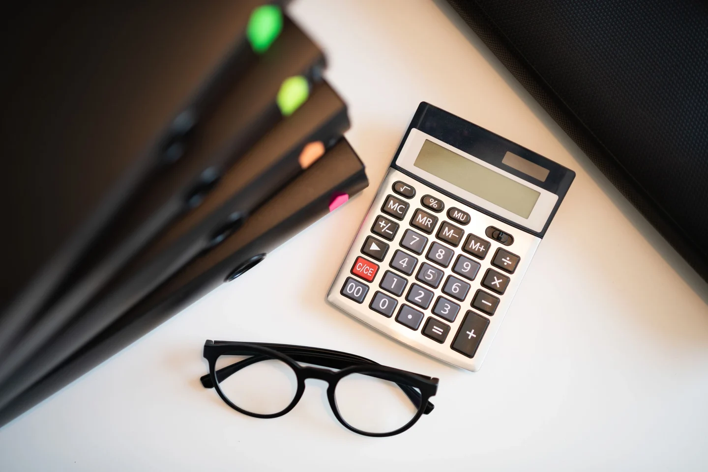 A desk with a calculator and glasses (illustrative)